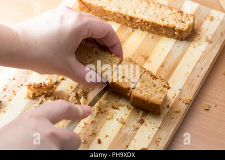 Weibliche Hände schneiden und vorbereiten Kuchen Kruste Stockfoto