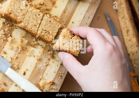 Weibliche Hände schneiden und vorbereiten Kuchen Kruste Stockfoto