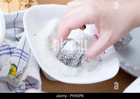 Weibliche Hände die Brownies mit Kokos Mehl Stockfoto