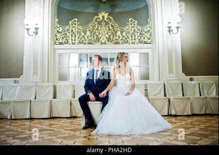 Schöne blonde Braut mit Bräutigam im grand palace Stockfoto