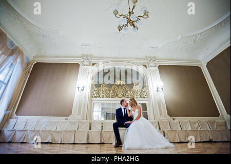 Schöne blonde Braut mit Bräutigam im grand palace Stockfoto