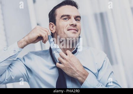 Charismatische Geschäftsmann seine Krawatte binden Stockfoto