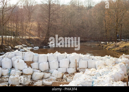 Viele große weiße Sandsäcke für Hochwasserschutz. Stockfoto