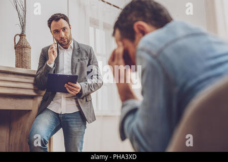 Geballte männliche Person, tief in Gedanken versunken Stockfoto