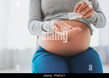 Fürsorgliche Mutter Vitamine zu geben, Ihre ältere Tochter Stockfoto