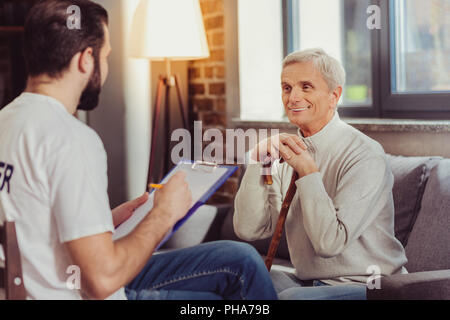 Angenehmen ruhigen Menschen sitzen und Lächeln. Stockfoto