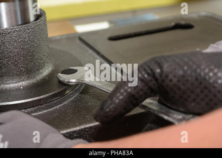 Handwerker ziehen Metallschraube mit Schraubenschlüssel - close-up Stockfoto