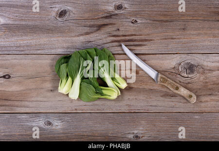 Chinesische Bok Choy und Schälmesser auf rustikalem Holz Stockfoto