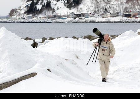Fotograf mit einem großen Objektiv (600 mm) im Schnee Stockfoto
