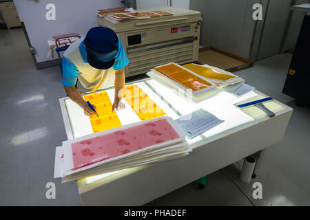 Mitarbeiter arbeiten bei Druckmaschinen Fabrik industrielle Einstellung Stockfoto