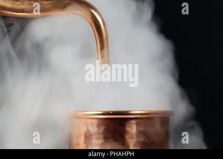 Ein Kupferrohr einer Brennerei mit Dampf. Stockfoto