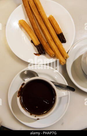 Heiße Schokolade und Churros zu trinken San Gines. Es gibt ein Cafe in der Nähe von Plaza Mayor, die hauptsächlich chocolate con churros seit 1894 dient. Madrid, Spanien Stockfoto