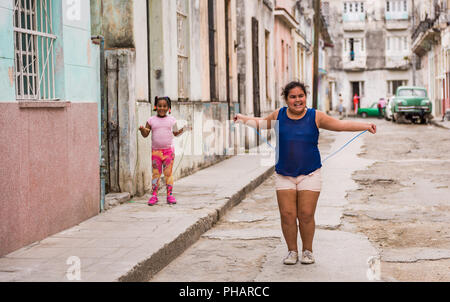 Havanna, Kuba/März 22, 2016: Glücklich lächelnde Mädchen spielen mit Seil springen in die Altstadt von Havanna Gasse. Stockfoto