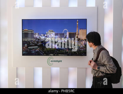 Berlin, Deutschland. 31 Aug, 2018. Ein Besucher an ein Fernsehgerät am Messestand von Philips im Jahr 2018 IFA Funkausstellung in Berlin, Hauptstadt der Bundesrepublik Deutschland, am 12.08.31, 2018 angezeigt. Die IFA 2018, der 1.814 Aussteller aus der ganzen Welt, begann am Freitag und wird noch bis Sept. 5. Credit: Shan Yuqi/Xinhua/Alamy leben Nachrichten Stockfoto