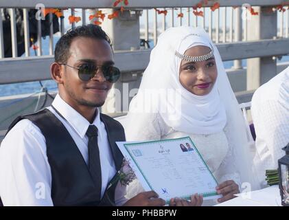 Männlich. 31 Aug, 2018. Eine maledivische Paar zeigen ihre Heiratsurkunden während einer Messe Hochzeit Zeremonie auf der China-Maldives Friendship Bridge in Male, Malediven am 12.08.31., 2018. Die China-Maldives Friendship Bridge, die ersten Sea Bridge auf den Malediven eröffnet Verkehr am Donnerstag Abend. Die Brücke ist eine Ikone Projekt der Malediven und China im Co-Gebäude des 21. Jahrhunderts Maritime Seidenstraße. Credit: Tang Lu/Xinhua/Alamy leben Nachrichten Stockfoto