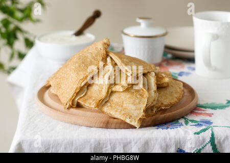 Frühstück Pfannkuchen serviert mit saurer Sahne und Honig. Selektive konzentrieren. Stockfoto