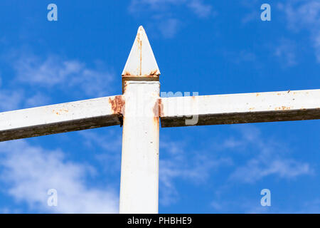 Stahl metall Zaun mit Rost gegen den blauen Himmel mit Wolken, Nahaufnahme Stockfoto