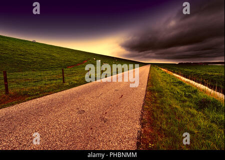 Straße entlang des schützenden Damm und Kanal Stockfoto