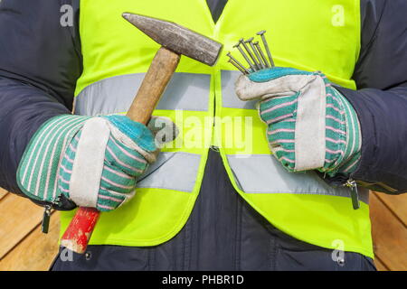 Hände halten Hammer und Nägel Stockfoto