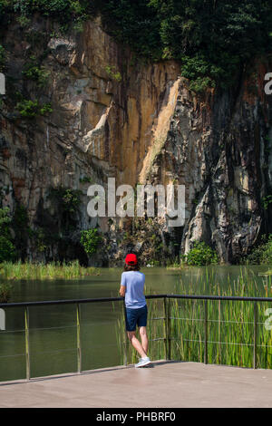 Rückansicht einer Frau, die aus dem Steinbruch blickt. Suchen Sie in einem Steinbruchpark nach Balance und verbinden Sie sich mit der Natur. Stockfoto