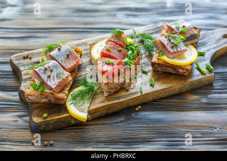 Toast mit Hering, Kaviar, grüne Zwiebeln und Dill. Stockfoto