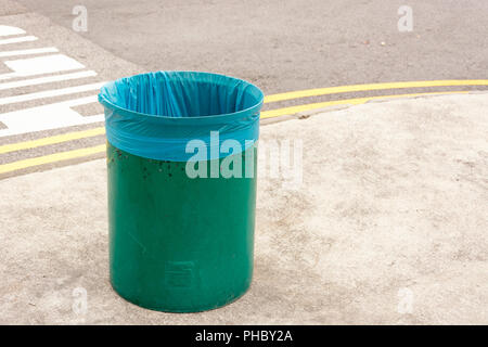 Single leer grün Abfallbehälter mit neuen und sauberen blauen Plastiktüte im öffentlichen Bereich. Bedeutete die Umwelt ordentlich, sauber und ordentlich zu halten. Stockfoto