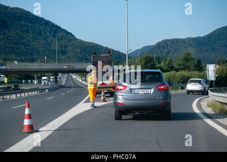 Roadworker Autos umleiten Autobahn an der Straßensperre aufgrund von Unfällen Stockfoto