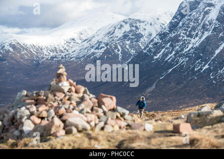 Ein Cairn und ein Wanderer an der Oberseite der Teufel Treppe beim Wandern entlang der West Highland Way in der Nähe von Glencoe in die schottischen Highlands, Schottland, Großbritannien Stockfoto