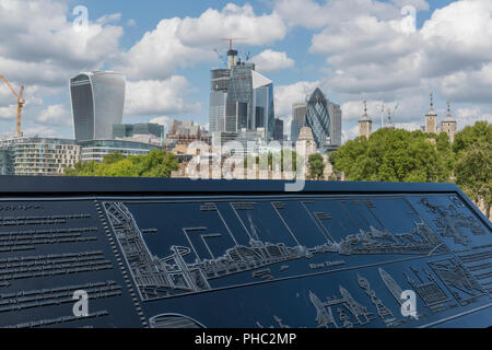 Stadt Skyline von London gesehen von der Tower Bridge mit einer Informationstafel oder Gebäude Karte im Vordergrund. Stockfoto