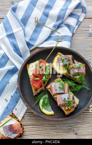 Geröstetes Brot mit Hering, Kaviar und Grüns. Stockfoto