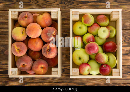 Kleine Holzkisten von gesunden frisches Obst mit reife Pfirsiche und vielfältige Äpfel gefüllt Blick von oben auf einen Tisch bei Farmers Market Stockfoto