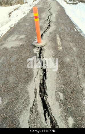 Langen riss Stretching überqueren Sie den Bürgersteig mit orangefarbenen Schild Stockfoto