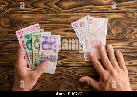 Mann mit chinesischen Yuan statt Türkische Lira in einem Konzept des Außenhandels und Wechselstube, Krise, Abwertung zu zahlen, und die Wirtschaftspolitik Stockfoto