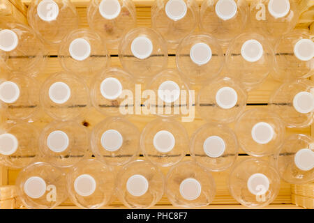 Dicht Reihen von leeren Plastikflaschen bereit für das Recycling versiegelt mit weissen Kappen gesehen in der Nähe von oben nach unten in einem full frame Hintergrund verpackt Stockfoto