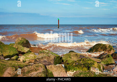 Wellen Waschen der Felsen auf das Meer Barrieren an Rossall Stockfoto