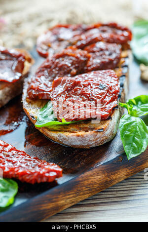 Bruschetta mit getrockneten Tomaten und Basilikum. Stockfoto