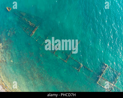 Die rostige Reste der alten Meer trocken Frachtschiff auf dem flachen Wasser. Antenne Top View Stockfoto