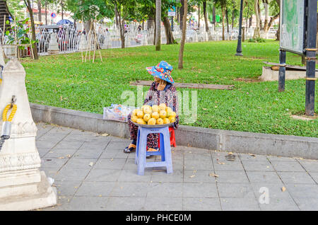 Phnom Penh, Kambodscha - 8. April 2018: Die Frau mit den typischen Kambodschanischen Kleidung Mangos verkaufen in einem Garten von Wat Phnom Pagode (Berg) Stockfoto