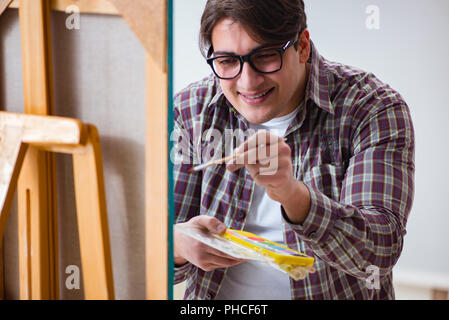 Junge männliche Künstler Zeichnung Bilder in helles studio Stockfoto