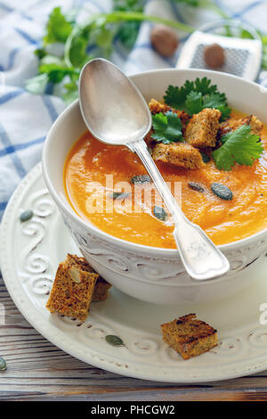 Würzige kürbissuppe in einer porzellanschale. Stockfoto