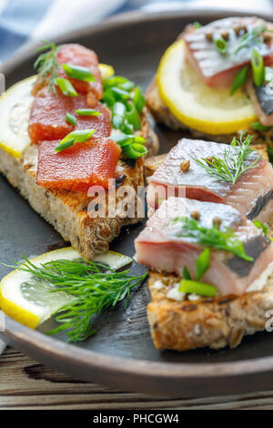 Brot mit Ricotta, Stücke von Hering und grüne Zwiebeln. Stockfoto