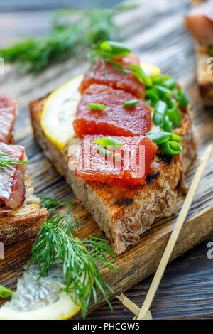 Geröstetes Brot mit Ricotta, Kaviar, Hering und grüne Zwiebeln. Stockfoto