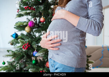 Die schwangere werdende Mutter während Weihnachten Stockfoto