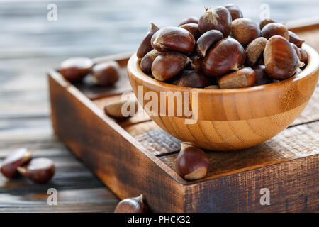 Raw Kastanien in eine hölzerne Schüssel. Stockfoto