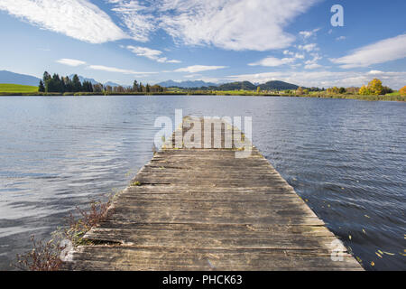 Hölzerne Seebrücke am See in der Region Allgäu in der Nähe der Stadt Füssen Stockfoto