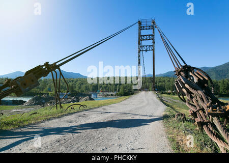 Ein Metall dicke Kabel Holding eine Brücke über einen Fluss. Stockfoto