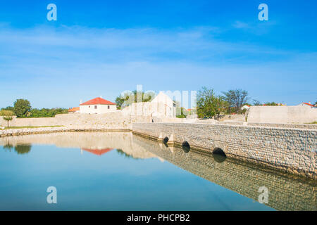 Alte steinerne Brücke und oberen Stadttor in der mittelalterlichen Altstadt von Nin, Dalmatien, Kroatien Stockfoto