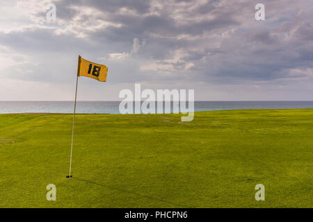 Varadero, Kuba/19. März 2016: Gelbe Flagge auf glatten grünen Rasen durch den Ozean bei kubanischen Golf Club. Stockfoto