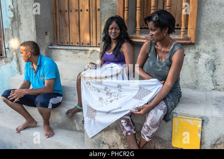 Zwei Frauen sitzen vor der Tür in Trinidad, Kuba Hand sticken eine Tischdecke auf dem Webstuhl, ein traditionelles Handwerk in Kuba. Stockfoto