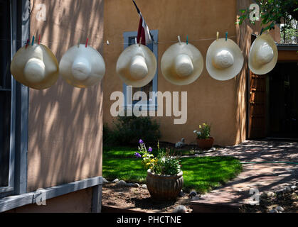 Strohhüte hängend auf einer Wäscheleine in einem hutgeschäft in Santa Fe, New Mexico USA. Stockfoto